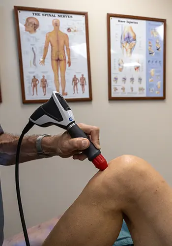 A photo of a patient receiving Radial Pressure Wave Therapy on their left knee.